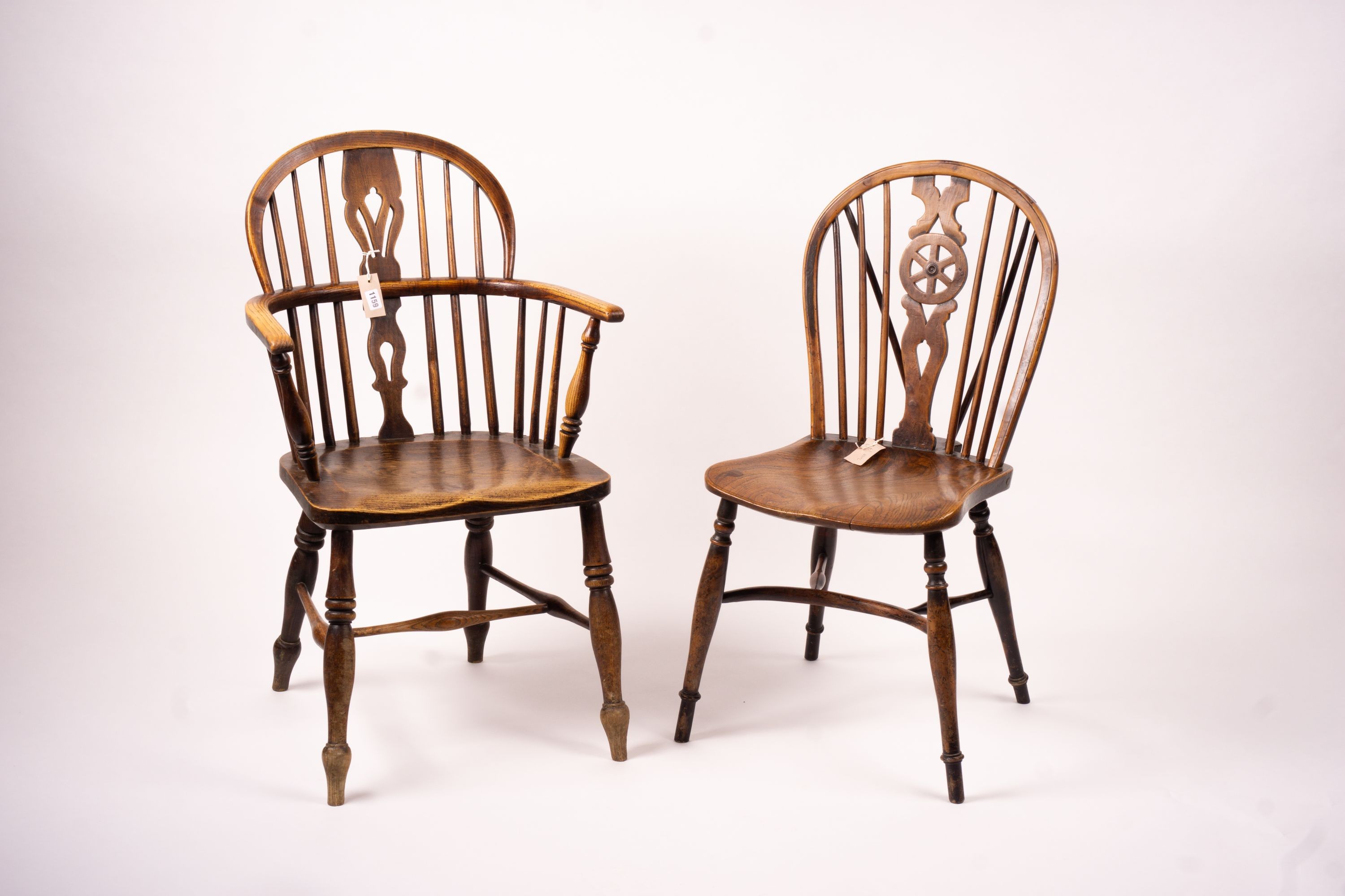 A mid 19th century ash and elm Derbyshire area Windsor elbow chair, together with a 19th century yew and elm Windsor wheel back chair with crinoline stretcher